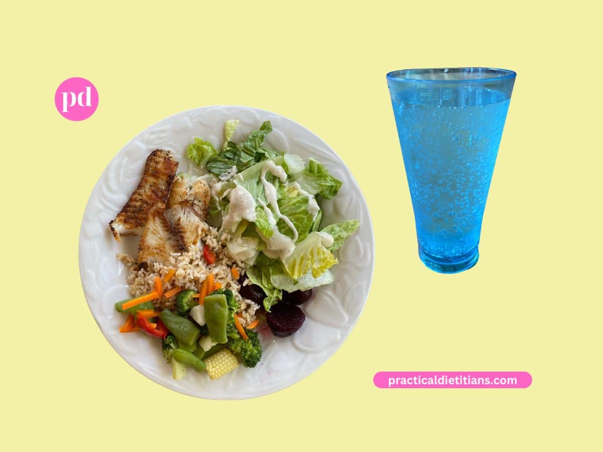 water in blue glass and plate of food with fish beets rice mixed veggies and salad with dressing